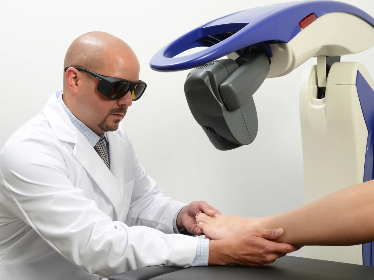 Clinician and patient wearing protective glasses during MLS laser treatment of the arm